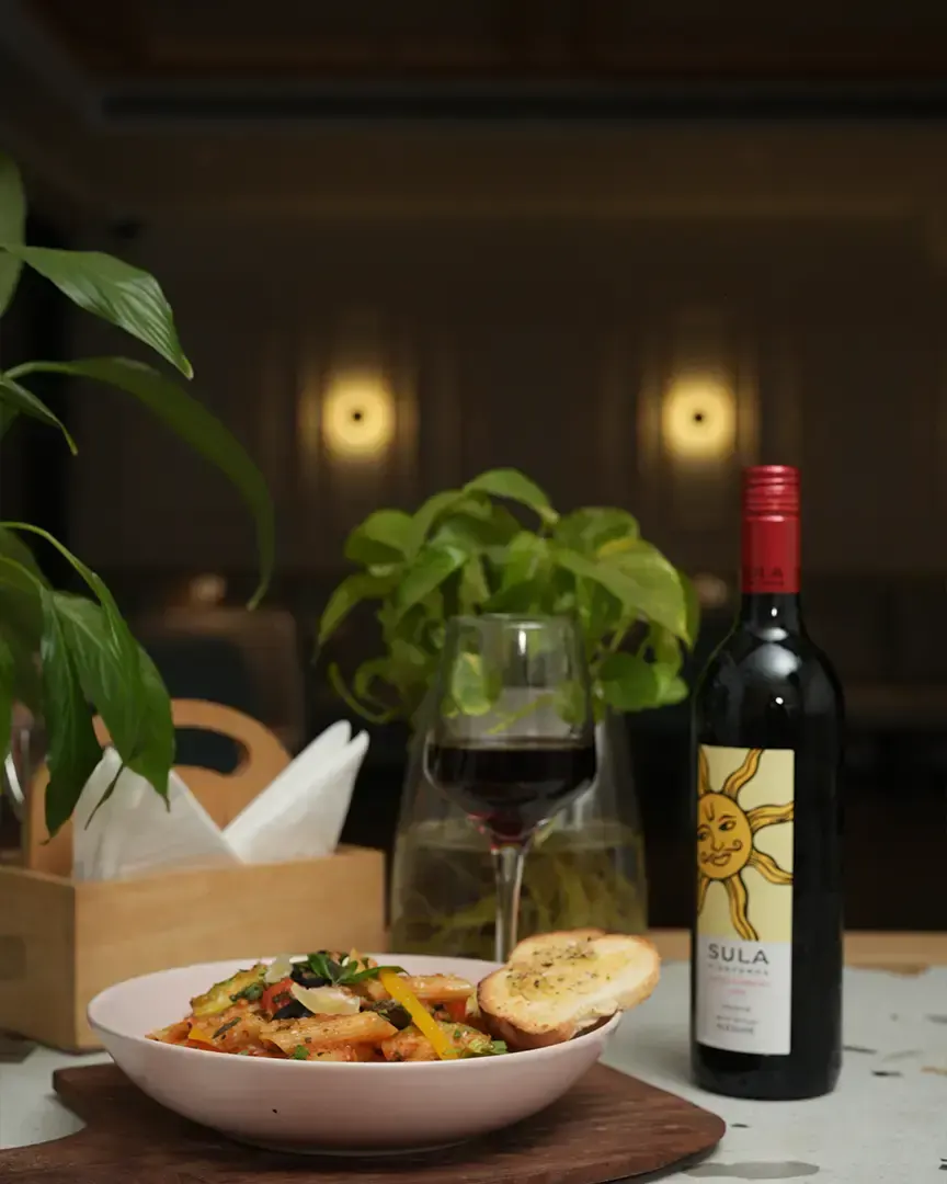 Pasta and a bottle of wine on a restaurant table